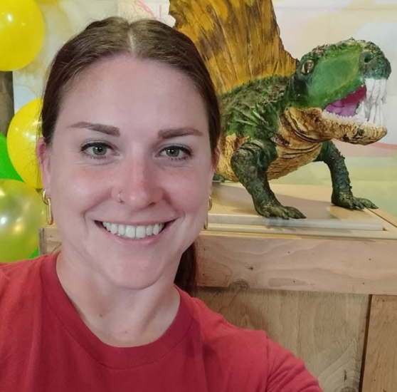 Image of board member Laura MacNeil, posed with a dimetrodon 