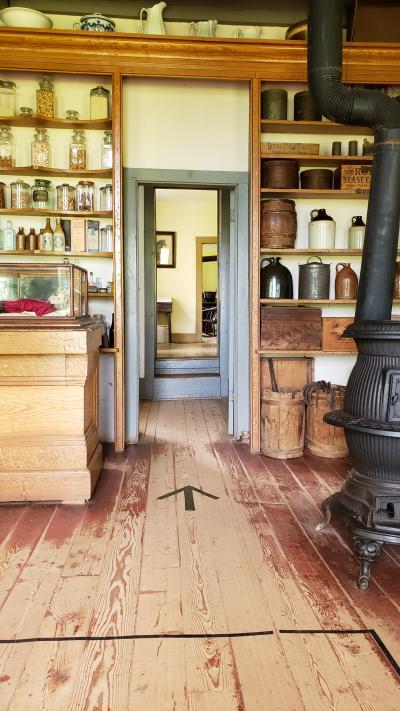 The interior of the Clark General Store at Orwell Corner Historic Village showing arrows on the floor where visitors can stand in order to maintain social distance.
